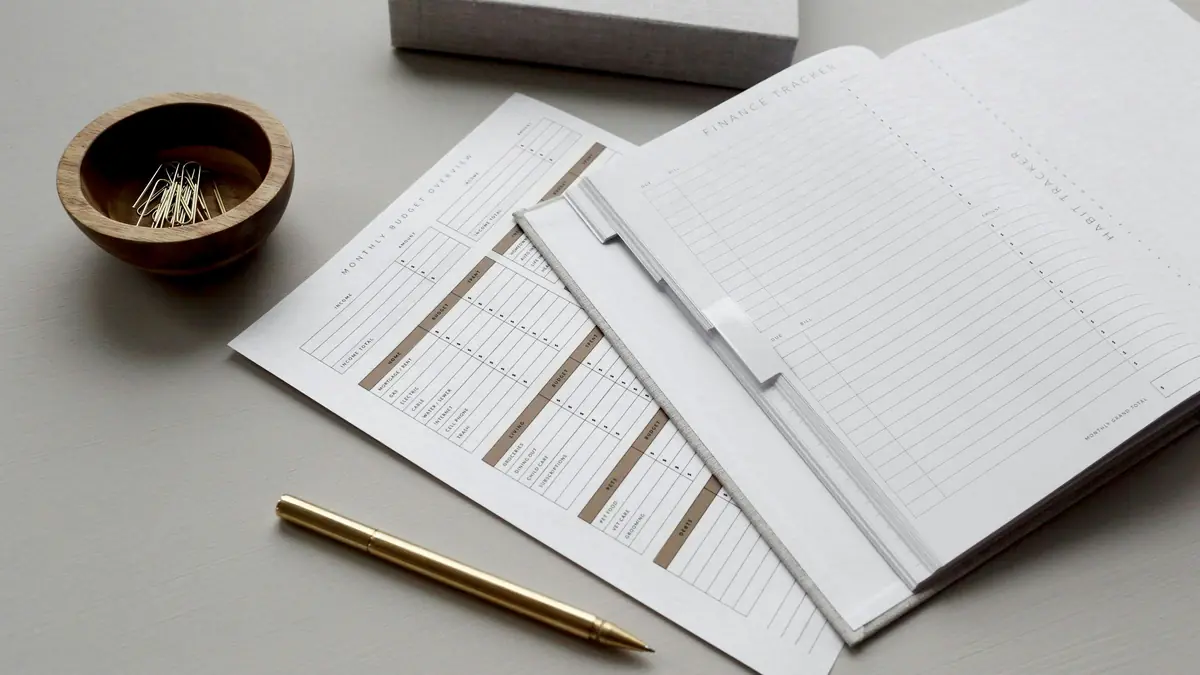 A financial planner with budget sheets and a pen.